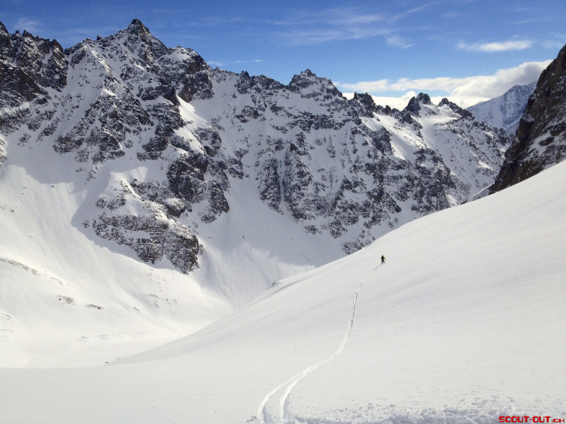 Skitourenspur unter verschneiten Felsgipfeln