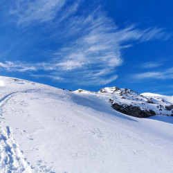 Aufstiegsspur in einem Schneehang unter blauem Himmel, Jahresrückblick 2020