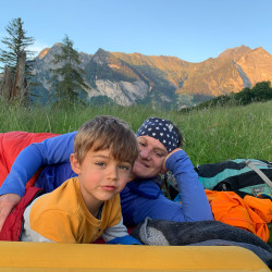 Erwachsener und Kind im Schlafsack vor Bergkulisse, Jahresrückblick 2020