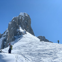 Skitourengänger unter einem verschneiten Felsgipfel, Jahresrückblick 2020