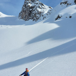 Snowboarder im Pulverschnee unter einer Felsspitze, Jahresrückblick 2021