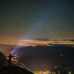 Person mit Stirnlampe unter dem Sternenhimmel, Biwak am Chäserrugg