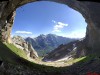 Blick aus einer Felshöhle auf ein Bergtal