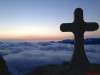 Gipfelkreuz über dem Nebelmeer in der Morgendämmerung