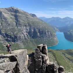 Bergsteiger auf einem Felsblock über einem Stausee, Jahresrückblick 2024