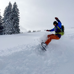 Snowboarder macht einen Trick im Pulverschnee, Jahresrückblick 2024