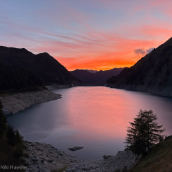 Stausee bei Sonnenuntergang mit rosa Wolken, Via Alta Crio zweiter Teil