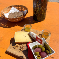 Apéro-Brett mit Käse, Brot und Oliven auf der Hüttenterrasse, Via Alta Crio