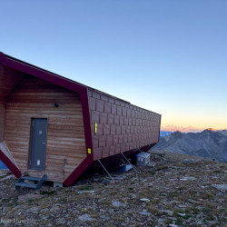 Moderne Biwakhütte mit roter Fassade in der Dämmerung, Via Alta Crio