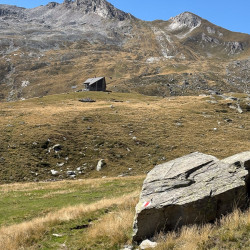 Alpweide mit Felsblöcken unter einem Bergkamm, Via Alta Crio