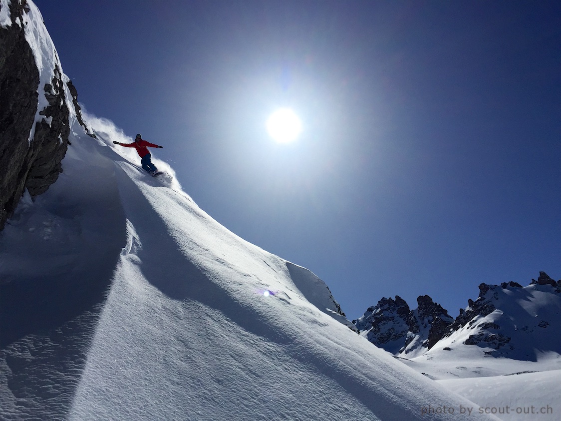 Snowboarder in steilem Gelände unter der Sonne