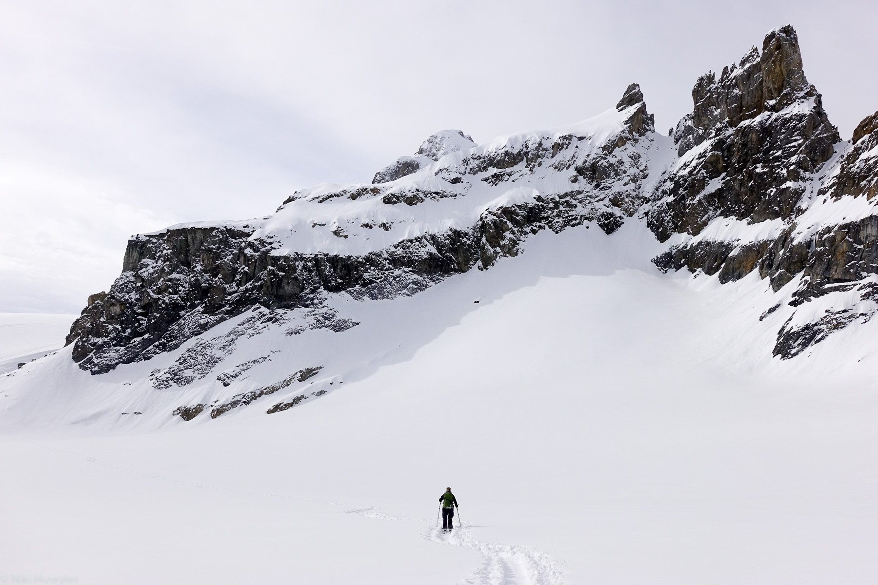 Skitourengänger in einer weiten Schneefläche unter Felsen, Jahresrückblick 2017