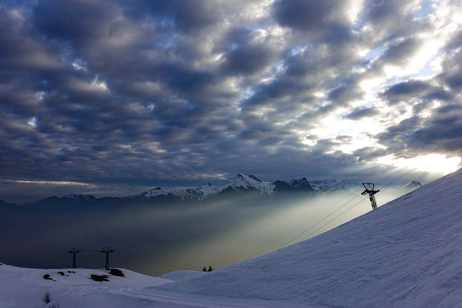 Sonnenstrahlen durch Wolken über einem Skigebiet, Jahresrückblick 2017