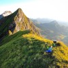 Grasgrat zu einem spitzen Gipfel mit Wanderer, Alpstein
