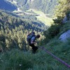 Bergsteiger mit Seil in einer bewaldeten Steilflanke, Fluebrig