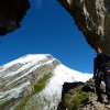Bergsteiger in einem Felstor vor verschneitem Gipfel, Fluebrig