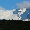 Gipfelkreuz vor verschneiten Bergen, Fluebrig