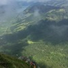 Wanderer in einer steilen Grasflanke im Nebel, Fluebrig