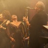 Band auf einer Bühne mit Saxophonist und Sängerinnen