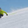 Skifahrer in gelber Jacke im Carving-Schwung