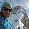 Selfie mit Sonnenbrille vor einem verschneiten Felsgipfel