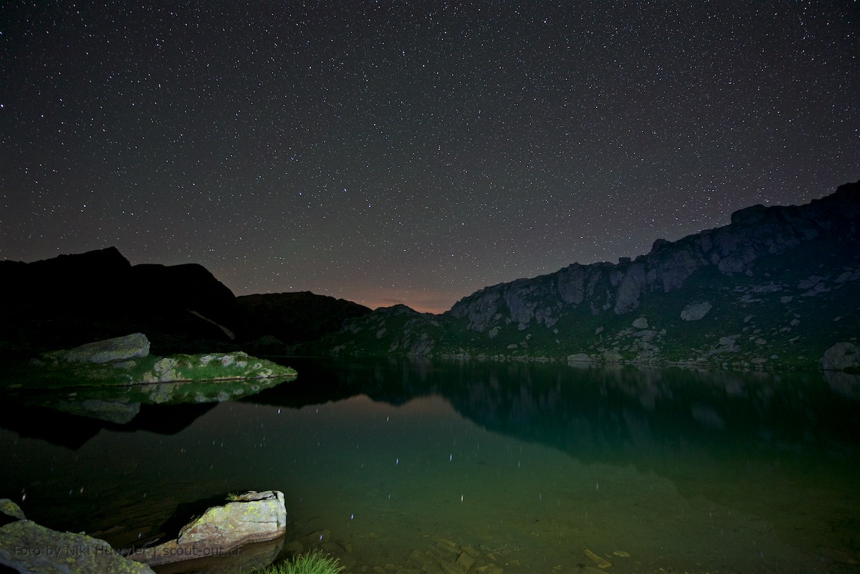 Nacht der Perseiden: Sternenhimmel spiegelt sich im Bergsee