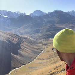 Selfie mit gelber Mütze über einem Bergtal, Sommer 2020