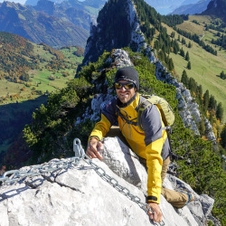 Kletterer in gelber Jacke auf einem Kalkgrat, Sommer 2020