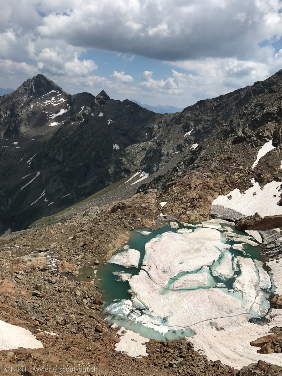 Gefrorener Bergsee mit Eisschollen unter Gipfeln, Via Alta della Verzasca