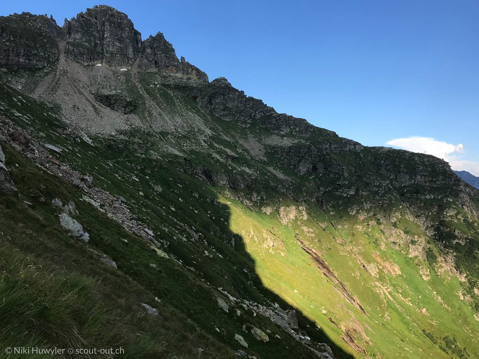 Grüne Bergflanke unter Felszacken, Via Alta della Verzasca