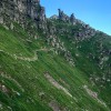 Bergweg in einer steilen Grasflanke unter Felstürmen, Via Alta della Verzasca