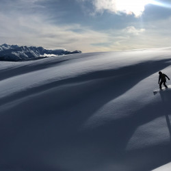 Splitboarder auf einem Schneerücken im Gegenlicht, Winter 2020